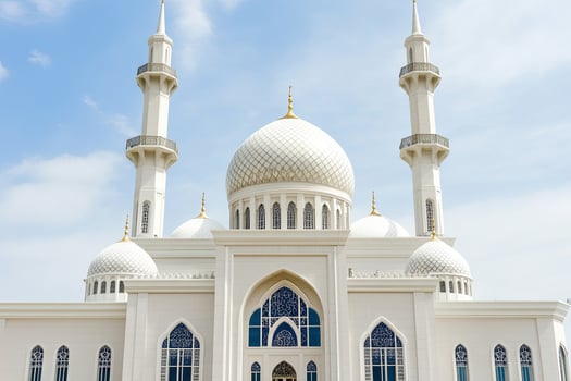 Majestic white mosque with two minarets under a blue sky. photo