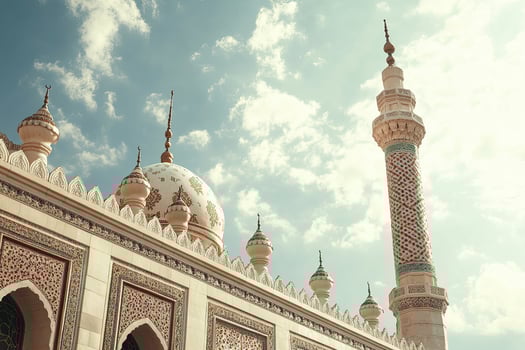 Ornate mosque dome and minaret against a blue sky. photo