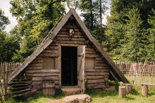 Triangular log houses with wooden roofs behind a fence. Montenegro, north photo