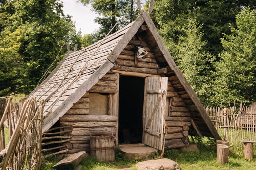 Triangular log houses with wooden roofs behind a fence. Montenegro, north photo