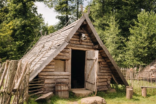 Triangular log houses with wooden roofs behind a fence. Montenegro, north photo