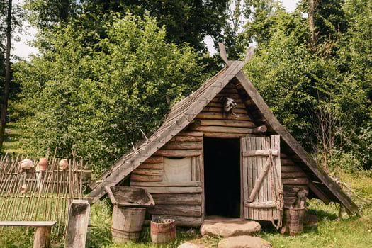 Triangular log houses with wooden roofs behind a fence. Montenegro, north photo