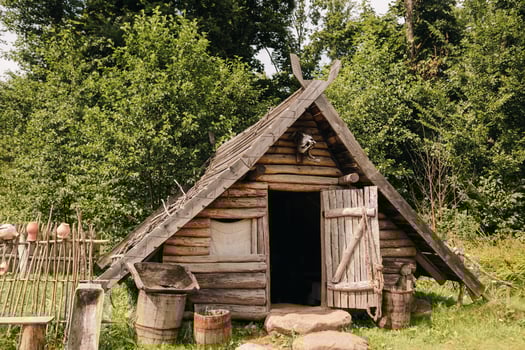 Triangular log houses with wooden roofs in an old medieval village photo