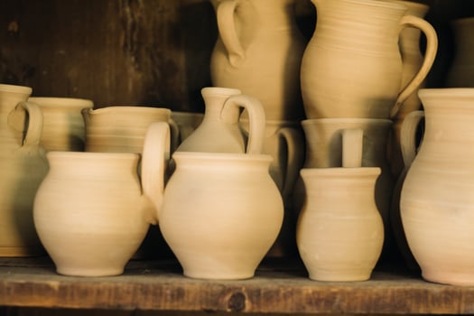 Ceramic clay jugs standing on a shelf in the village photo
