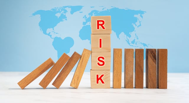 Risk management and strategy in business. Close-up of wooden blocks on a line of dominos over a marble floor photo