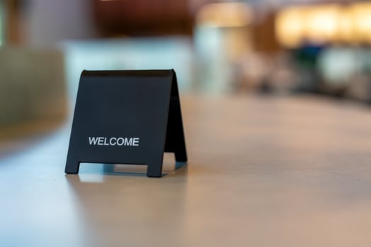 Black sign there is a message saying Welcome with a copy space is placed on a cement table for Enter the text of restaurant, store, or cafe. photo