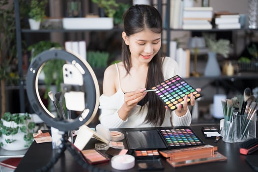 a beauty blogger woman is holding a makeup palette and looking at it. photo