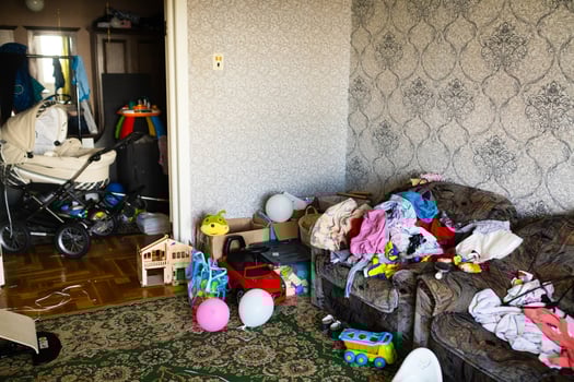 A mess in the room. A lot of things are lying around the apartment. House is in the room photo