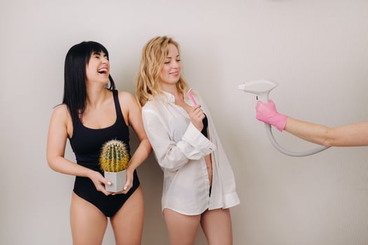 Cactus concept. Unshaven body . One girl is holding a cactus in her hands, and the second girl is holding a razor. Symbol of unshaven body parts photo