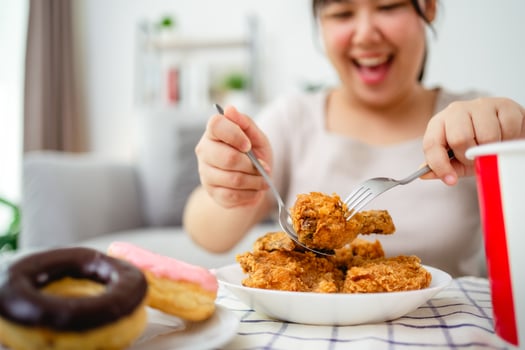 Beautiful Asian woman eating fried chicken, smiling with a happy face. photo