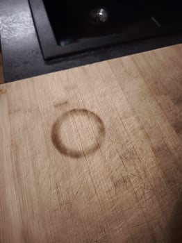 Round burn mark on wooden chopping board in kitchen photo