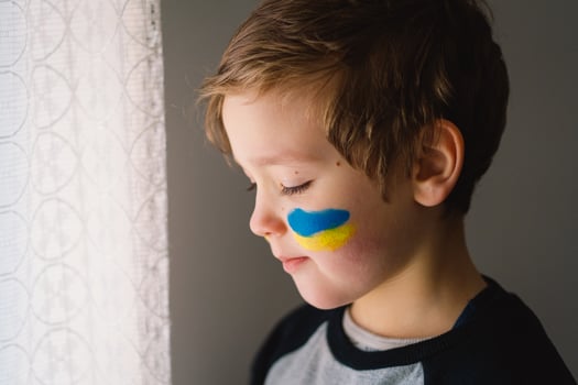 Portrait of a Ukrainian boy with a face painted with the colors of the Ukrainian flag. photo