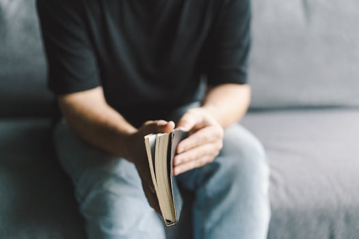 Christian man holds holy bible in hands. Reading the Holy Bible in a home. photo