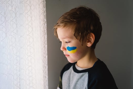 Portrait of a Ukrainian boy with a face painted with the colors of the Ukrainian flag. photo