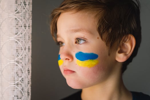 Portrait of a Ukrainian boy with a face painted with the colors of the Ukrainian flag. photo