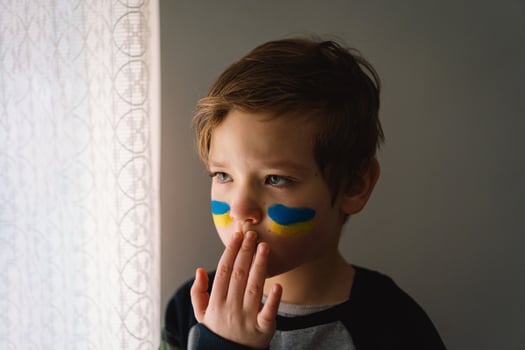 Portrait of a Ukrainian boy with a face painted with the colors of the Ukrainian flag. photo