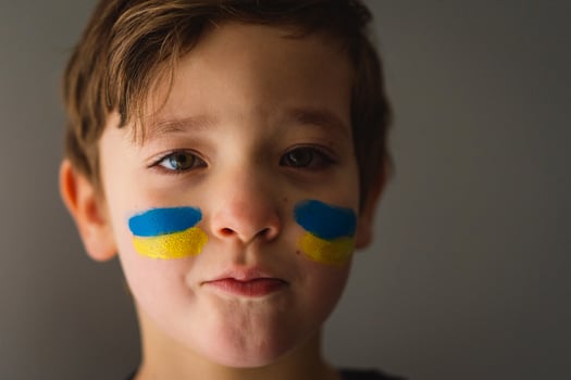 Portrait of a Ukrainian boy with a face painted with the colors of the Ukrainian flag. photo