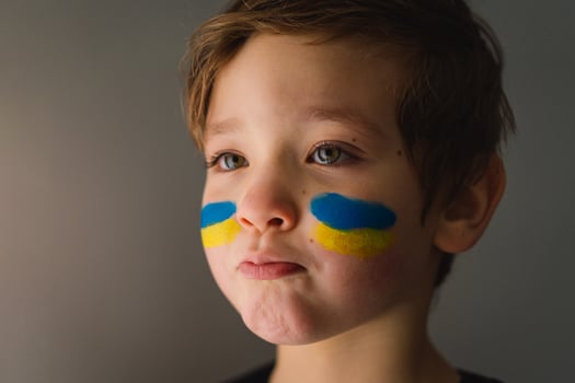 Portrait of a Ukrainian boy with a face painted with the colors of the Ukrainian flag. photo
