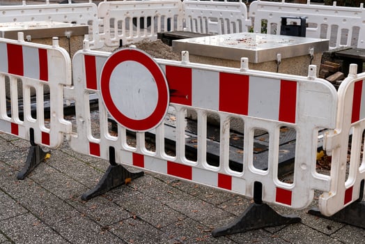 Red and white barriers restrict access to a construction site in an photo