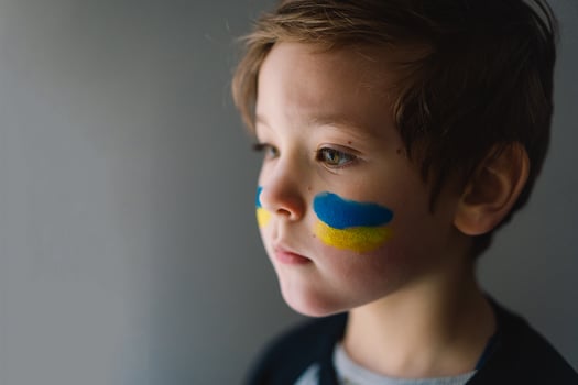 Portrait of a Ukrainian boy with a face painted with the colors of the Ukrainian flag. photo