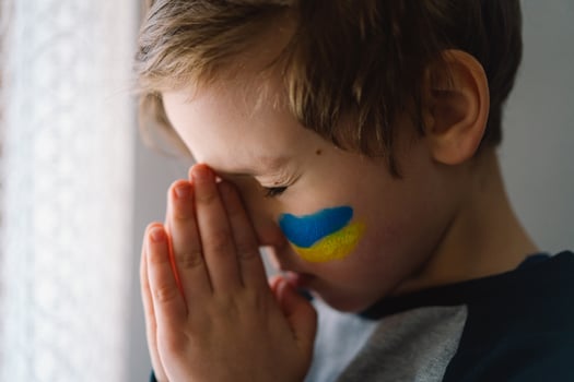 Ukrainian boy closed her eyes and praying to stop the war in Ukraine. photo