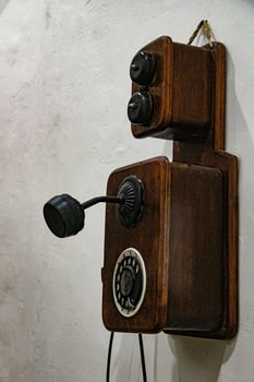 An Aged and Working Antique Telephone. Old style antique telephone fixed on a wall. photo