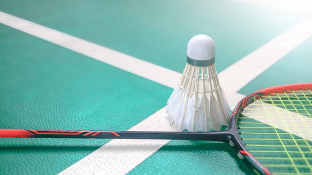 White badminton shuttlecocks and badminton rackets on green floor indoor badminton court. Concept for badminton competition and its lovers. photo