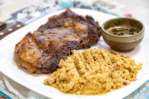 Typical Brazilian lunch with grilled steak, farofa and sauce photo