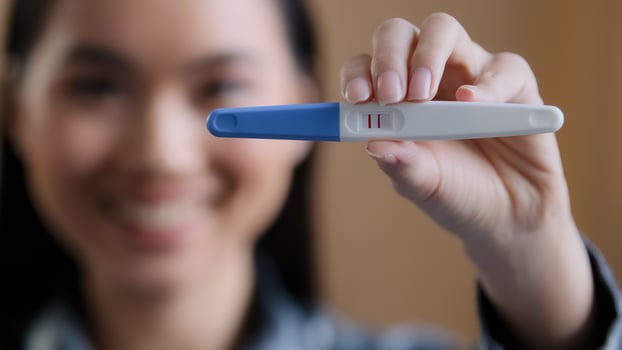 Portrait defocused asian girl pregnant happy woman expectant future mother holding showing positive pregnancy test expecting baby new life infant parenthood fertility female health gynecology service photo