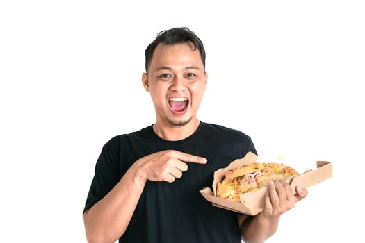 Happy Asian Man Points to a Piece of Delicious Pizza in His Hand photo