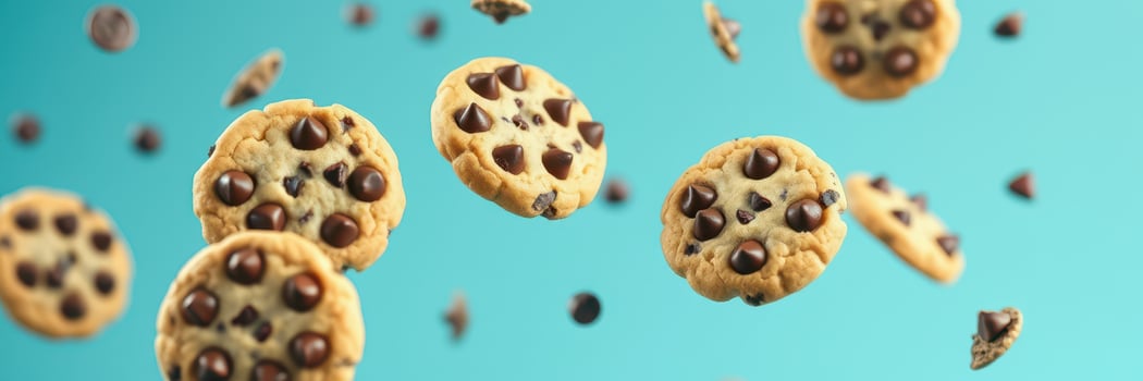 Floating chocolate chip cookies above a blue background create a whimsical dessert display photo