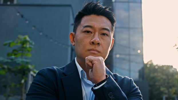 Close-up dreaming thinking pensive 40s Asian Korean man puzzled confused thoughtful decision problem solution. Adult Chinese businessman entrepreneur employer in city solving problem pondering idea photo