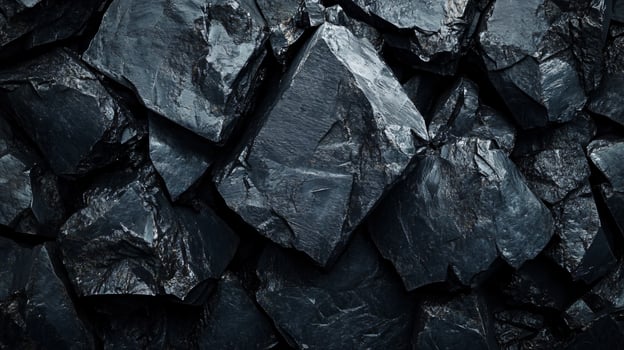 Close up of a pile of rocks with a dark color. The rocks are piled up in a way that they form a square shape. The image has a moody and mysterious feel to it photo