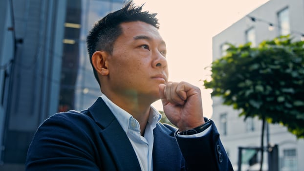 Dreaming alone thinking pensive 40s Asian Korean man puzzled confused thoughtful decision problem solution. Adult Chinese businessman entrepreneur employer in city solving problem pondering idea photo