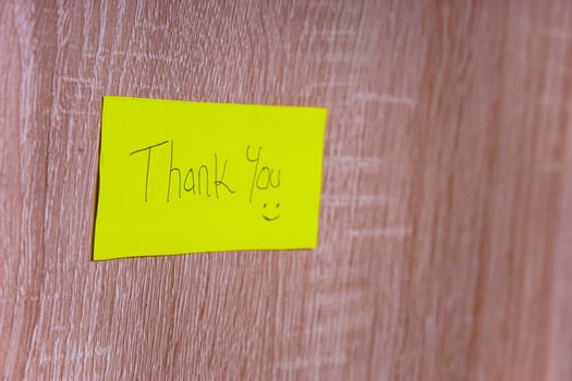A cheerful note saying Thank You on a bright yellow sticky note, enhancing positivity in any space. photo