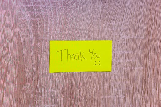 A cheerful note saying Thank You on a bright yellow sticky note, enhancing positivity in any space. photo