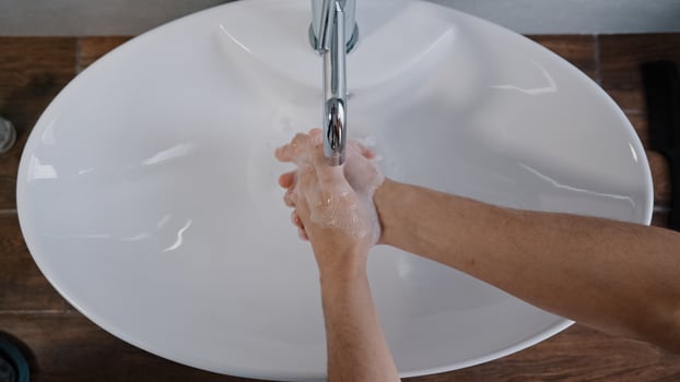 Close-up male hands washing in large white sink at home in bathroom in hotel daily hygiene body care man wash hand treatment washes palms cleans bacteria coronavirus outbreak prevention in hotel room photo