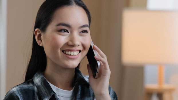 Asian girl answering phone call chatting with friends calling mobile phone laughing smiling friendly conversation remote chat communication portrait millennial korean lady ordering with smartphone photo