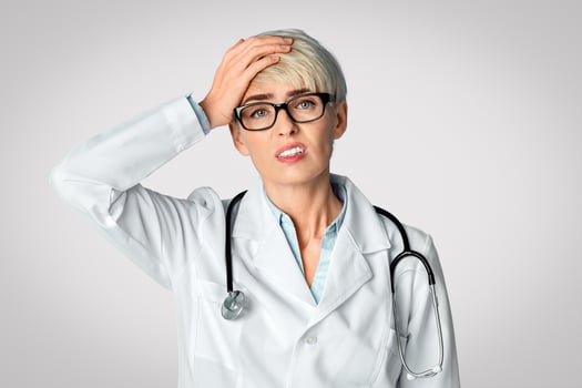 Problems in medicine. Upset adult woman doctor holding to head, panorama photo