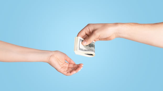 Unrecognizable man giving money to woman on light background, close up of hands photo