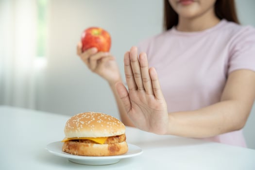 Beauty slim female body confuse hamburger. Woman in restaurant achieves weight loss goal for healthy life, crazy about thinness, thin waist, nutritionist. Diet, body shape. photo