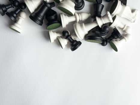 Collection of black and white chess pieces on a minimalist white background photo