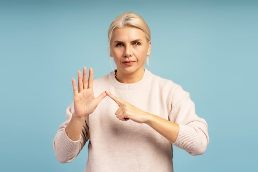 Serious woman showing small amount or tiny size with hand gesture on blue background photo