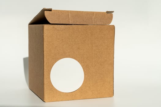 National Cartonnage Day. Cardboard box with white round sticker. Minimal product packaging design photo