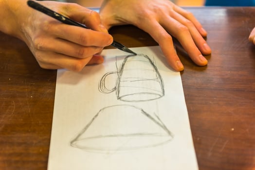 woman hands drawing a draft of a future clay cup photo