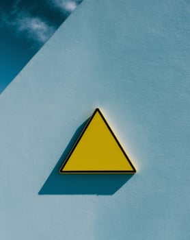Blank Yellow Triangle Warning Sign on Blue Wall photo