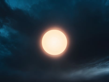 A dark sky with a glowing circle in the middle photo