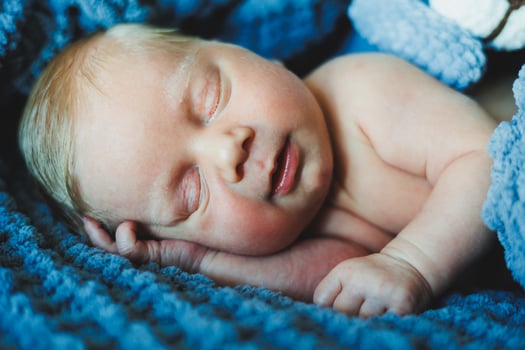 A newborn baby sleeps on a knitted blanket. A blanket made of natural fabric for a newborn baby. Baby sleep photo