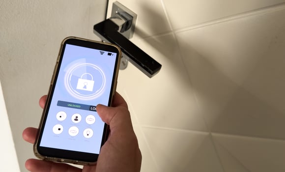 Smart house, home automation, device with App icons. Man uses his smartphone with smarthome app to control the lights of his house. photo
