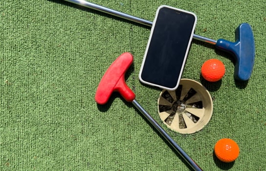 Series with golf clubs, smartphone and balls on artificial grass. photo